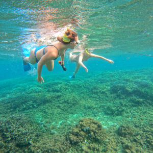 two-girls-snorkelling-in-shallow-clear-water-above-corals-on-Pigeon-Island-in-Nilaveli